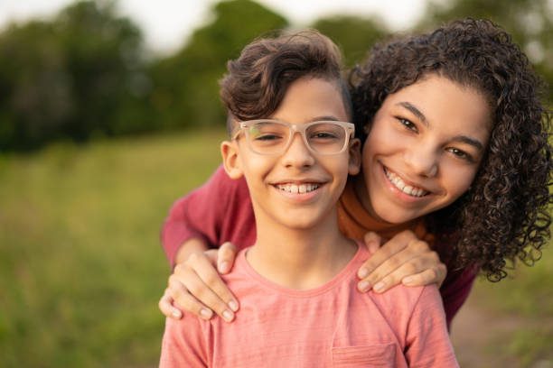 Two children smile for the camera, showing their healthy teeth